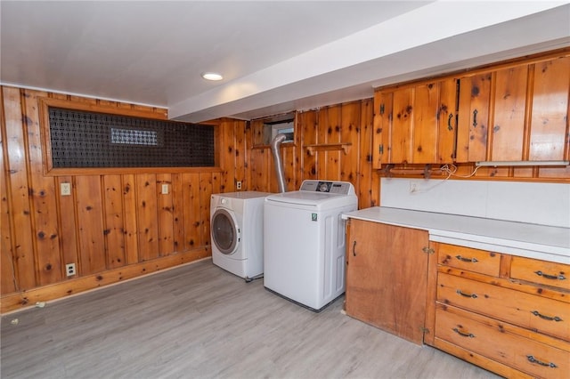70 Enfield Ave, Providence, RI 02908 - washroom featuring cabinet space, light wood-style flooring, wood walls, and washing machine and dryer