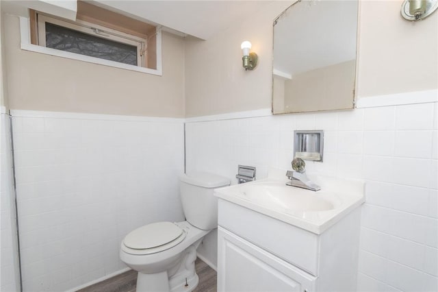 70 Enfield Ave, Providence, RI 02908 - bathroom featuring tile walls, toilet, wood finished floors, vanity, and wainscoting