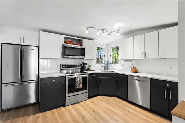 22 Dunedin St, Cranston, RI 02920 - kitchen featuring stainless steel appliances, a sink, white cabinets, light wood-style flooring, and tasteful backsplash