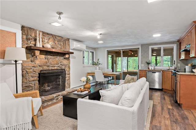 310 Old Coach Rd, Charlestown, RI 02813 - living room featuring an AC wall unit, dark wood-style flooring, and a stone fireplace