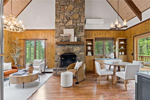 310 Old Coach Rd, Charlestown, RI 02813 - living room featuring a chandelier, high vaulted ceiling, wooden walls, a baseboard radiator, and healthy amount of natural light