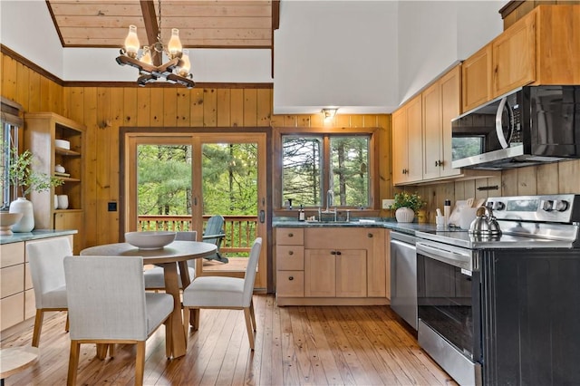310 Old Coach Rd, Charlestown, RI 02813 - kitchen with appliances with stainless steel finishes, a chandelier, plenty of natural light, a sink, and wooden walls