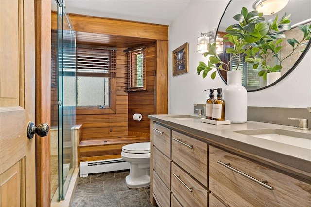 310 Old Coach Rd, Charlestown, RI 02813 - bathroom featuring a baseboard heating unit, wood walls, toilet, stone finish flooring, and double vanity