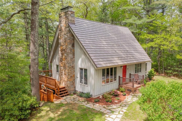310 Old Coach Rd, Charlestown, RI 02813 - view of front facade featuring a chimney, board and batten siding, a deck, and a forest view