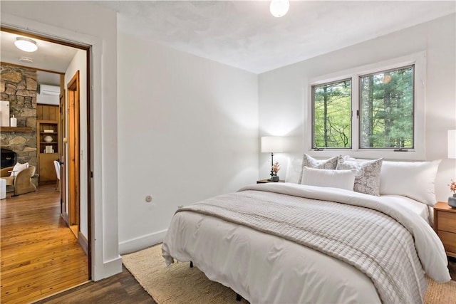 310 Old Coach Rd, Charlestown, RI 02813 - bedroom featuring dark wood-style flooring, baseboards, and a wall unit AC