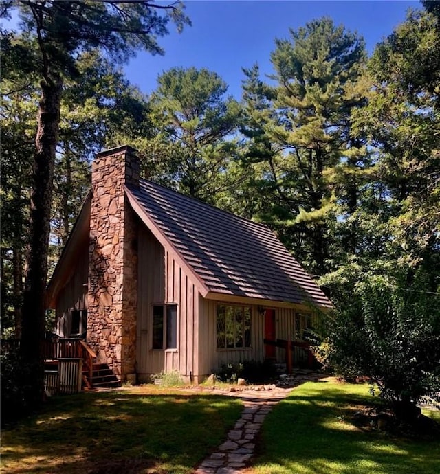 310 Old Coach Rd, Charlestown, RI 02813 - view of front facade featuring board and batten siding, a chimney, and a front lawn