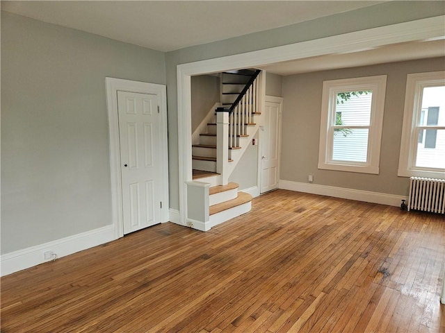 29 Arthur St, Warwick, RI 02888 - spare room with radiator, wood-type flooring, stairway, and baseboards