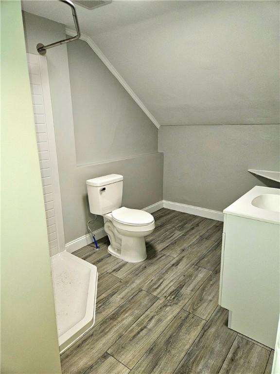 29 Arthur St, Warwick, RI 02888 - bathroom with vaulted ceiling, toilet, a shower, wood finished floors, and baseboards