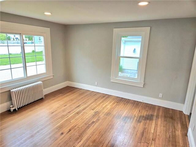29 Arthur St, Warwick, RI 02888 - unfurnished room featuring radiator, baseboards, light wood-style floors, and recessed lighting