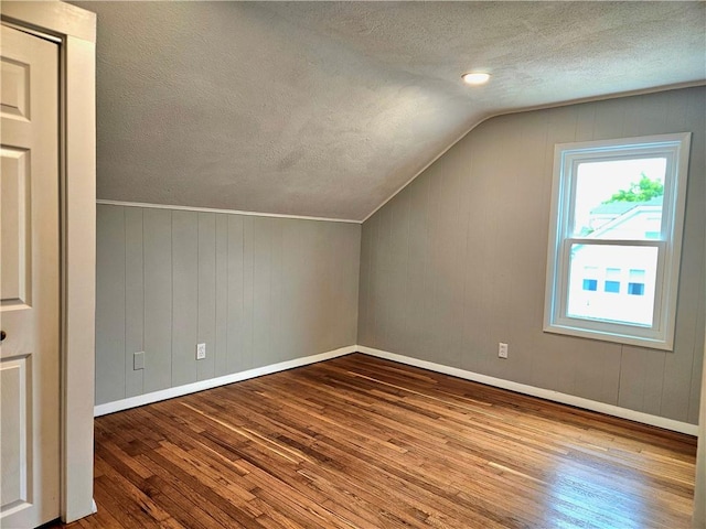 29 Arthur St, Warwick, RI 02888 - bonus room featuring wood-type flooring, a textured ceiling, vaulted ceiling, and baseboards