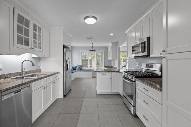 446 Paddock Ln, Bristol, RI 02809 - kitchen featuring appliances with stainless steel finishes, a sink, white cabinetry, glass insert cabinets, and a peninsula