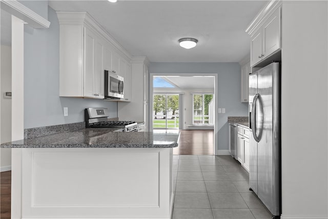 446 Paddock Ln, Bristol, RI 02809 - kitchen with appliances with stainless steel finishes, white cabinets, a peninsula, dark stone countertops, and baseboards