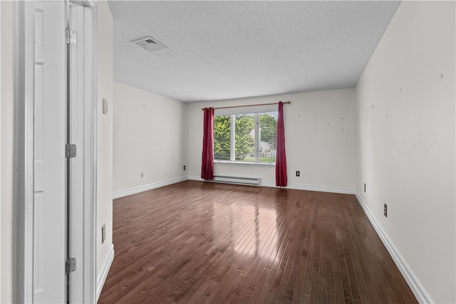 446 Paddock Ln, Bristol, RI 02809 - empty room with a baseboard heating unit, dark wood-style floors, a textured ceiling, and baseboards