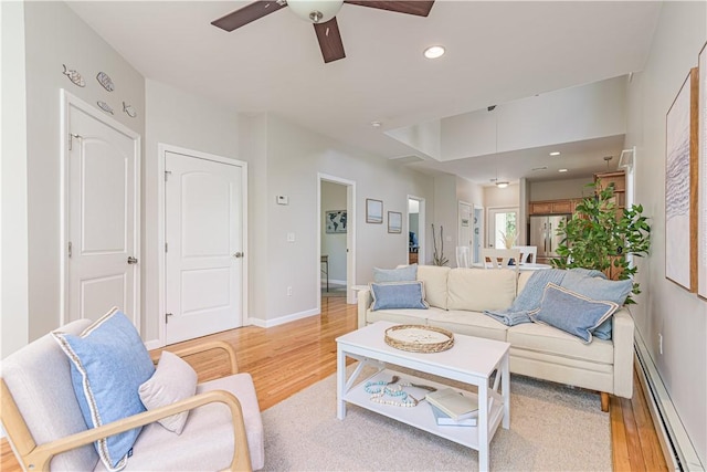 10 Kristin Ct, Coventry, RI 02816 - living room with a baseboard heating unit, ceiling fan, light wood finished floors, recessed lighting, and baseboards