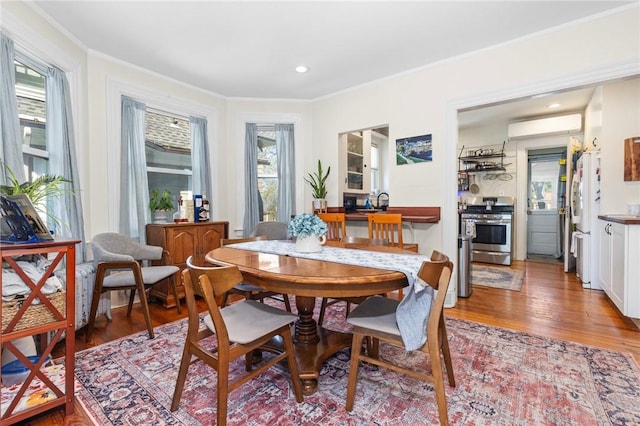 143 Ivy St, Providence, RI 02906 - dining space featuring light wood finished floors, crown molding, a wall mounted air conditioner, and recessed lighting