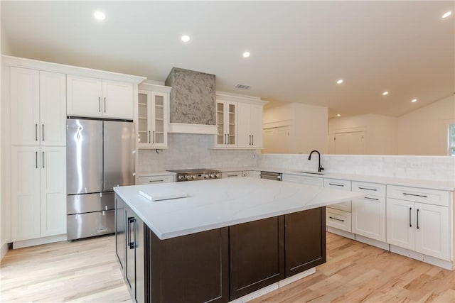 68 Orchard Ave, Johnston, RI 02919 - kitchen with appliances with stainless steel finishes, tasteful backsplash, a center island, light wood-style flooring, and recessed lighting