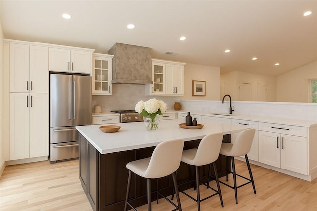 68 Orchard Ave, Johnston, RI 02919 - kitchen with freestanding refrigerator, a sink, premium range hood, light wood-type flooring, and backsplash