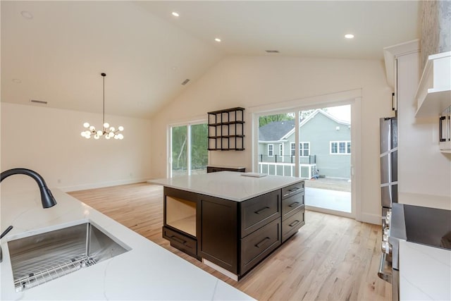 68 Orchard Ave, Johnston, RI 02919 - kitchen featuring a sink, light wood-type flooring, pendant lighting, dark brown cabinetry, and a chandelier
