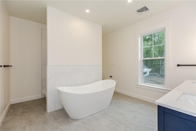 68 Orchard Ave, Johnston, RI 02919 - full bathroom featuring a soaking tub, double vanity, baseboards, recessed lighting, and tile walls