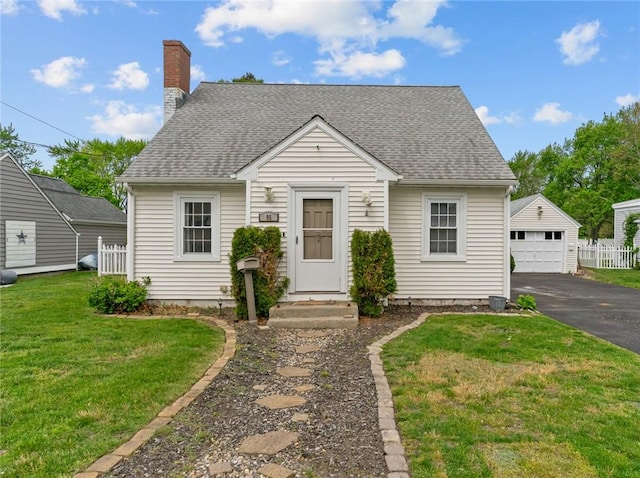 95 George Arden Ave, Warwick, RI 02886 - view of front of house with a detached garage, an outbuilding, a chimney, a shingled roof, and asphalt driveway
