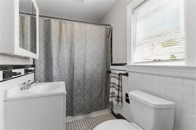95 George Arden Ave, Warwick, RI 02886 - bathroom featuring tile walls, vanity, toilet, a shower with shower curtain, and a wainscoted wall
