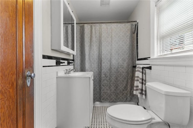 95 George Arden Ave, Warwick, RI 02886 - bathroom featuring tile walls, toilet, vanity, a wainscoted wall, and a shower with shower curtain