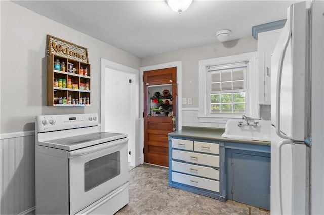 95 George Arden Ave, Warwick, RI 02886 - kitchen with white appliances, a sink, blue cabinets, and a wainscoted wall