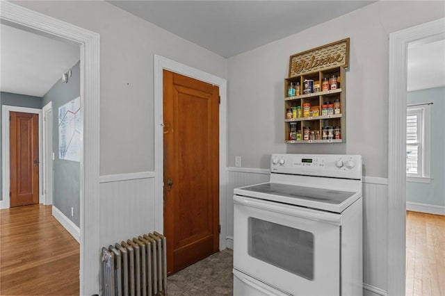 95 George Arden Ave, Warwick, RI 02886 - kitchen featuring electric range, radiator heating unit, wainscoting, and wood finished floors