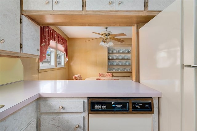 20 Loxley Rd, Providence, RI 02908 - kitchen with freestanding refrigerator, a ceiling fan, light countertops, and a peninsula