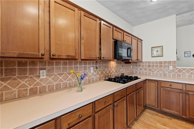 32 Trolley Ln, Westerly, RI 02891 - kitchen featuring black appliances, brown cabinets, light countertops, and decorative backsplash