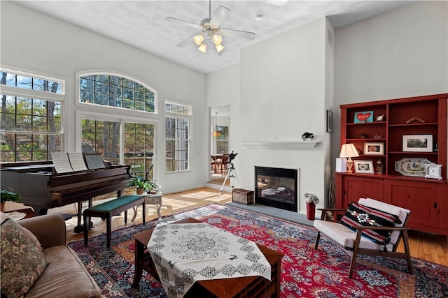 32 Trolley Ln, Westerly, RI 02891 - living area featuring a towering ceiling, plenty of natural light, ceiling fan, a fireplace, and wood finished floors