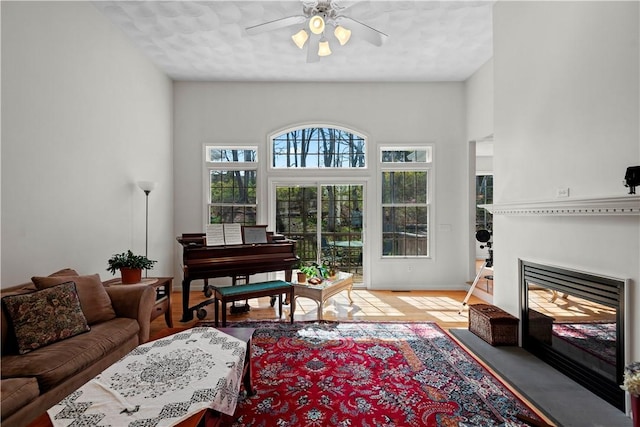32 Trolley Ln, Westerly, RI 02891 - living room with ceiling fan, wood finished floors, a fireplace with flush hearth, and baseboards