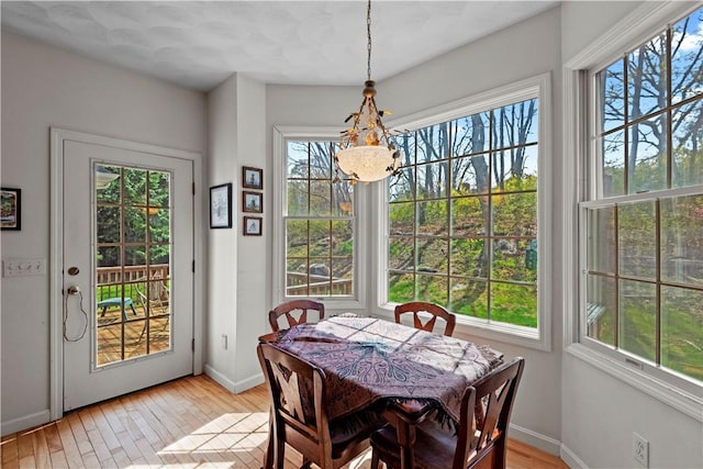 32 Trolley Ln, Westerly, RI 02891 - dining area with light wood-style floors, a chandelier, and baseboards