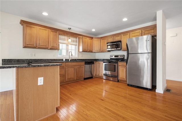 5 Enzo Dr, Coventry, RI 02816 - kitchen featuring appliances with stainless steel finishes, a peninsula, light wood-style floors, brown cabinets, and a sink