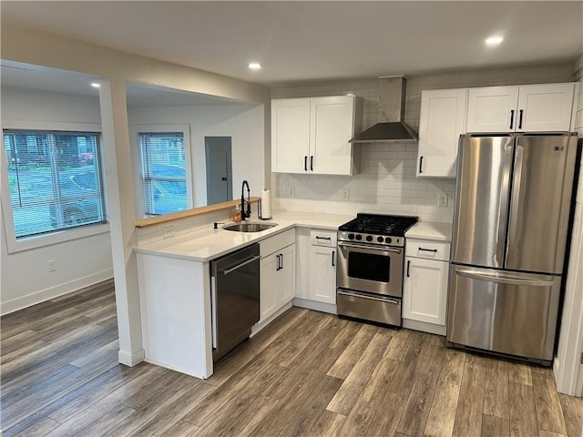 111 Samuel Gorton Ave, Warwick, RI 02889 - kitchen featuring stainless steel appliances, wall chimney exhaust hood, a sink, light countertops, and white cabinets