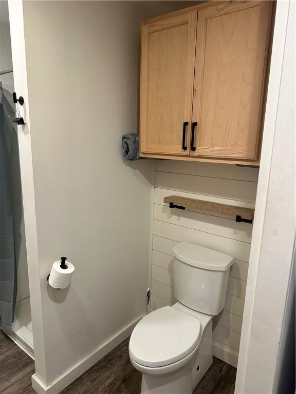 111 Samuel Gorton Ave, Warwick, RI 02889 - bathroom featuring wood finished floors, toilet, a shower, and baseboards