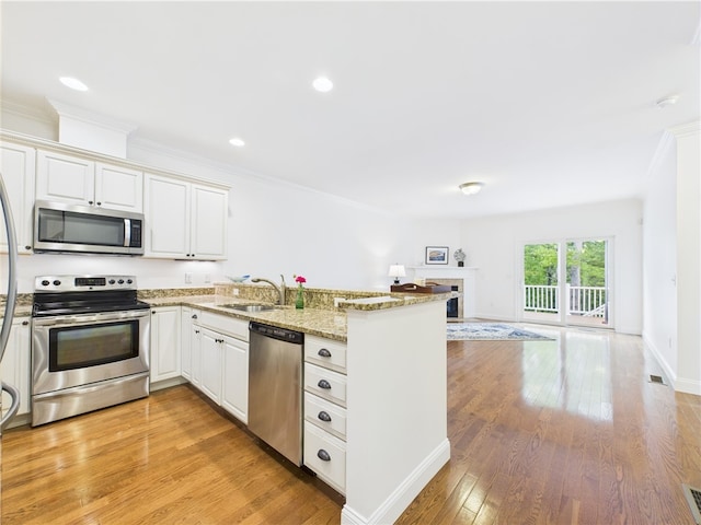 147 Southwinds Dr, South Kingstown, RI 02879 - kitchen with appliances with stainless steel finishes, a peninsula, open floor plan, a sink, and white cabinets