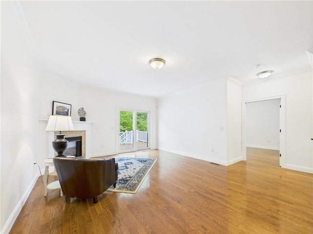 147 Southwinds Dr, South Kingstown, RI 02879 - living area featuring ornamental molding, light wood-type flooring, a glass covered fireplace, and baseboards