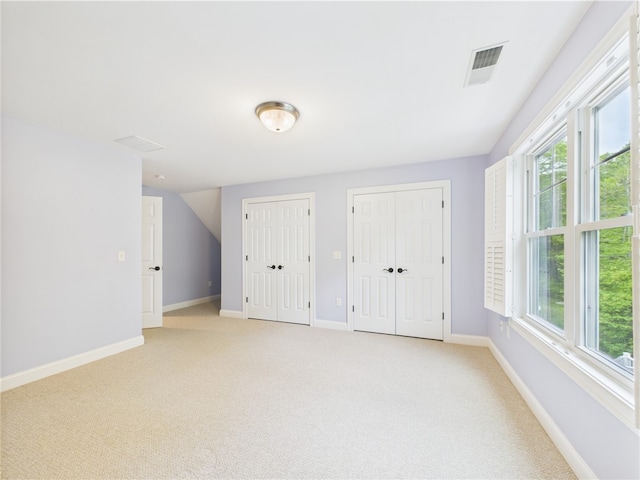 147 Southwinds Dr, South Kingstown, RI 02879 - unfurnished bedroom with two closets, light carpet, and baseboards