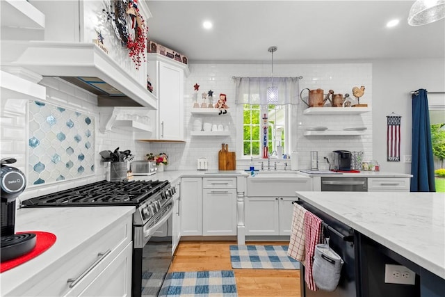 360 Pleasant St, East Providence, RI 02916 - kitchen featuring appliances with stainless steel finishes, open shelves, light wood-style floors, white cabinetry, and a sink