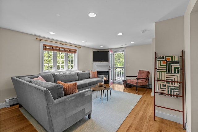 30 First School St, Bristol, RI 02809 - living room with baseboard heating, healthy amount of natural light, a glass covered fireplace, recessed lighting, and light wood-style flooring