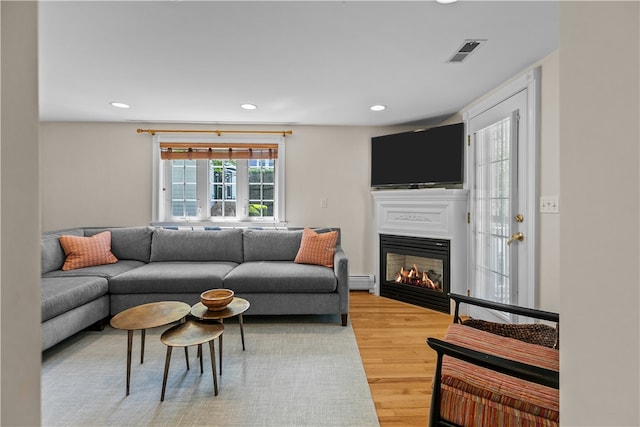 30 First School St, Bristol, RI 02809 - living room with light wood-style flooring, recessed lighting, a glass covered fireplace, and a baseboard heating unit