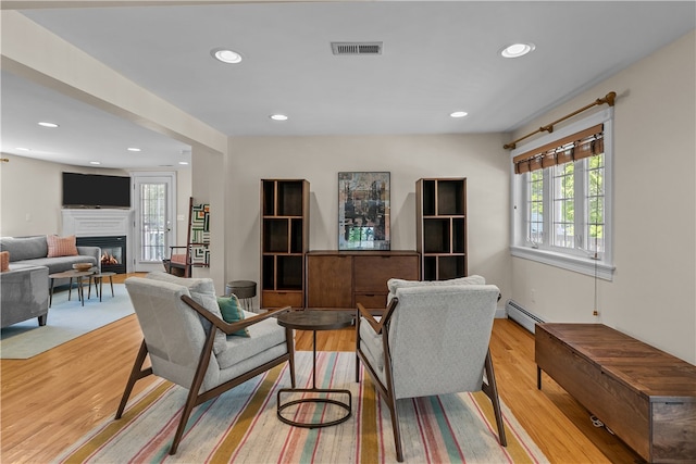 30 First School St, Bristol, RI 02809 - living area with a baseboard radiator, light wood-type flooring, a glass covered fireplace, and recessed lighting
