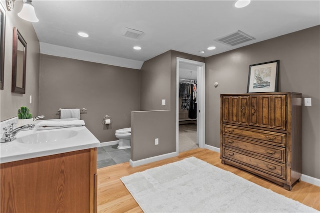 30 First School St, Bristol, RI 02809 - bathroom featuring double vanity, toilet, baseboards, recessed lighting, and wood finished floors