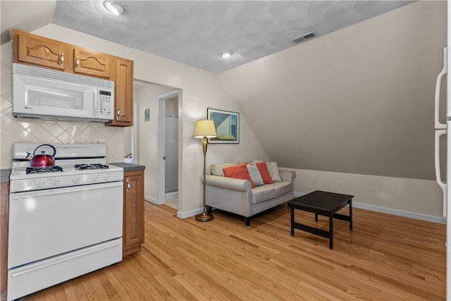 30 First School St, Bristol, RI 02809 - kitchen featuring white appliances, lofted ceiling, light wood-style flooring, backsplash, and baseboards
