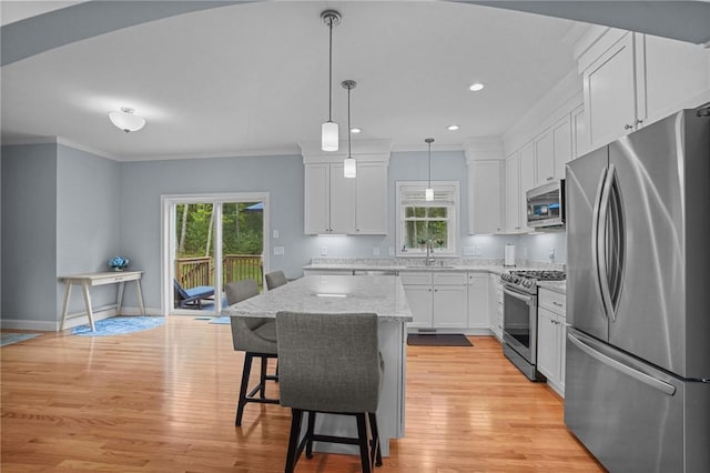 4 Overlook Cir, Coventry, RI 02816 - kitchen with stainless steel appliances, crown molding, white cabinets, light wood finished floors, and a kitchen island