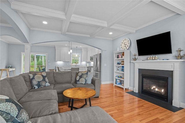 4 Overlook Cir, Coventry, RI 02816 - living room featuring arched walkways, light wood-style floors, a fireplace with flush hearth, coffered ceiling, and beam ceiling