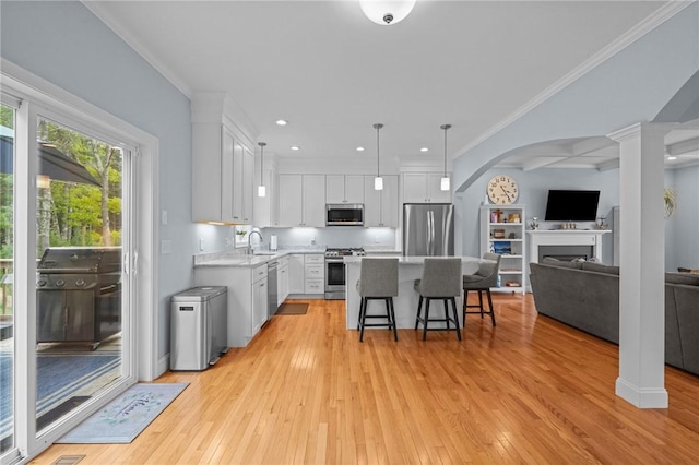 4 Overlook Cir, Coventry, RI 02816 - kitchen featuring appliances with stainless steel finishes, arched walkways, a kitchen bar, light wood-style flooring, and light countertops