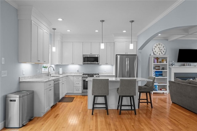 4 Overlook Cir, Coventry, RI 02816 - kitchen with stainless steel appliances, open floor plan, a sink, arched walkways, and a kitchen breakfast bar