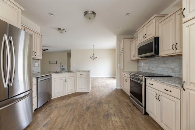 109 Chickadee Ln Unit A24, South Kingstown, RI 02879 - kitchen with stainless steel appliances, a peninsula, decorative backsplash, baseboards, and recessed lighting